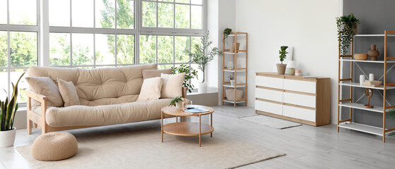 Interior of living room with soft couch, table and big window