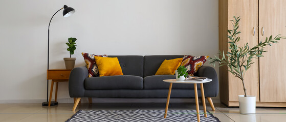 Interior of modern living room with black sofa, tables and lamp