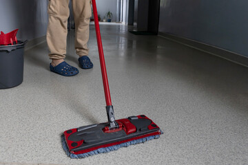 Cleaning the floor with a mop in a hallway during a routine cleaning session