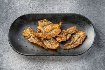 Dried fish snack on black plate