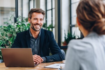 Businessman interviewing client with laptop in modern office