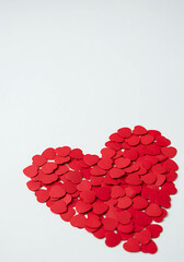 Red paper hearts arranged in a heart shape on a light background  