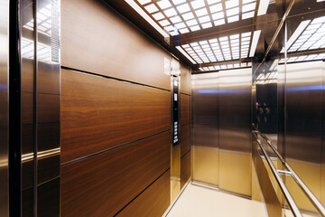 Modern elevator interiors blend elegant wood with sophisticated metal finishes for an inviting feel © Kantemir Production