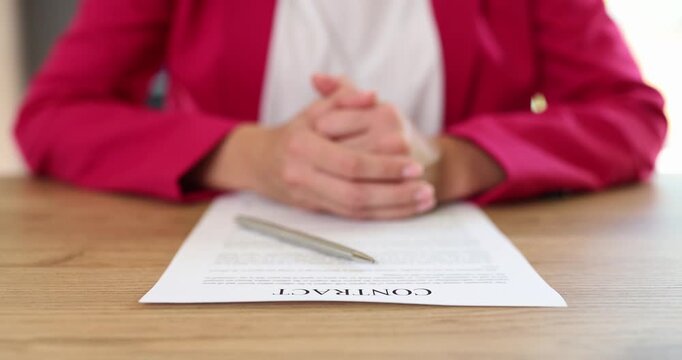Contract document with metal pen on wooden desk of female manager. Business agreement paper ready for signification and businesswoman in office