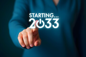 A person pointing at a glowing starting 2033 graphic on a screen with a blue shirt in the background
