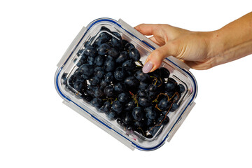 Hand holding a glass container filled with fresh black grapes, isolated on transparent background,...