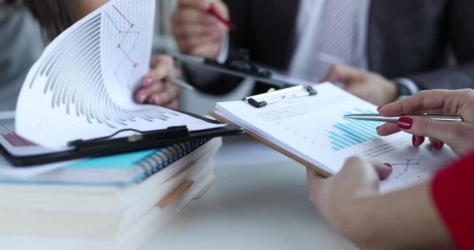 Marketing team analyzes commercial data with charts in board room at meeting. Colleagues plan future activities of business company in office - Powered by Adobe