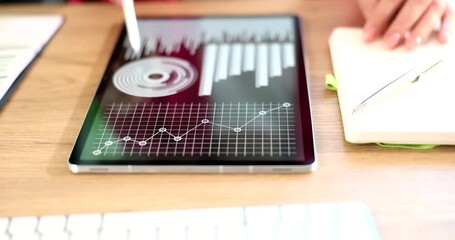 Businesswoman hand swipes infographics on digital tablet in office. Female business professional controls stock market trends via mobile device - Powered by Adobe