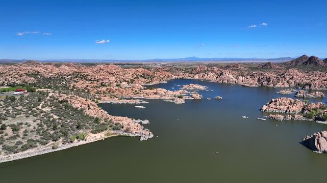 Aerial view of Watson Lake revealing the granite dells amidst the serene water under a clear blue sky, Watson Lake, Prescott, Arizona, United States.