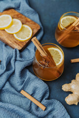 Spiced apple cider with lemon, cinnamon sticks, and star anise on blue cloth