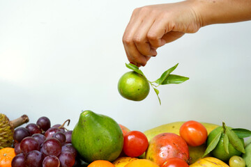 Green lime with a hand. fruit background.