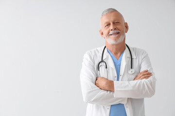 Portrait of senior doctor on grey background