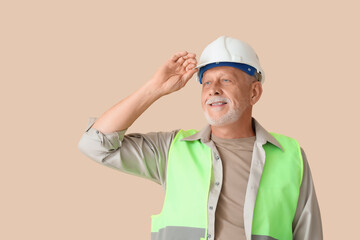 Portrait of senior construction worker on beige background