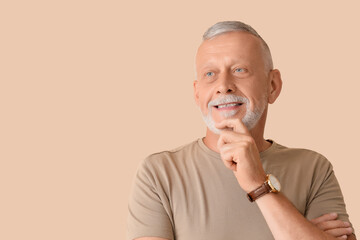 Portrait of senior man on beige background