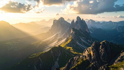 Golden Light Shines on Jagged Peaks with Green Slopes and Misty Shadows in High Altitude Landscape