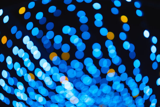 Blue and yellow light circles bokeh background pattern with dark night sky