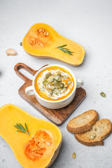 Butternut squash soup with pumpkin seeds, cream, rosemary, and toasted bread