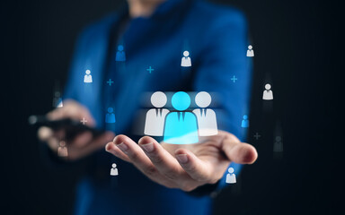 Customer Relationship Management system with businessperson holding virtual people icons,...