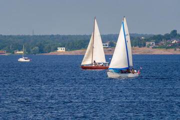 Fototapeta premium Two sailboats on lake near coastal town on a summer day