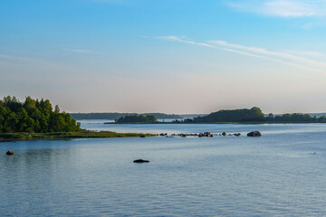 Peaceful lake landscape with rocky shoreline and distant forest