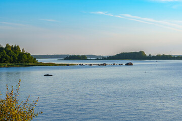 Peaceful lake landscape with rocky shoreline and distant forest