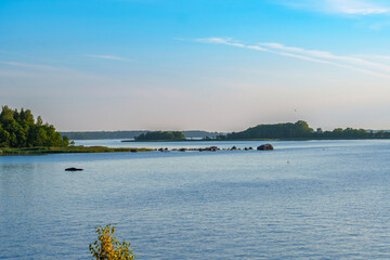 Peaceful lake landscape with rocky shoreline and distant forest