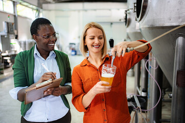 Women brewing beer doing quality control in microbrewery