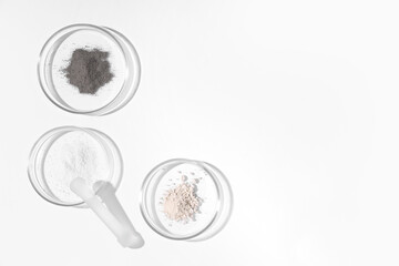 Petri dishes with powder and pestle on white background
