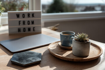 A cozy work-from-home setup with a laptop, a succulent plant, and a cup of coffee on a wooden table.
