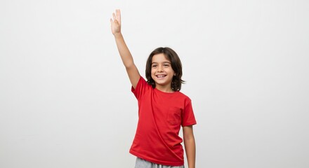 Smiling child in red shirt raises arm against a neutral white backdrop