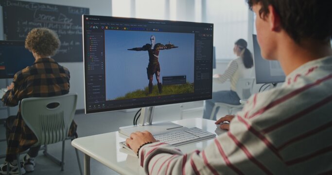 Boy in Classroom Works on 3D Modeling Project at Computer. Young Man Concentrated on Screen with Animation Software. Concept of Creative Education, Digital Design and Future Professions. Static Shot.
