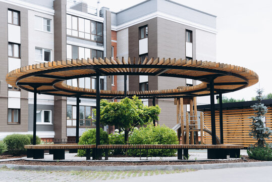 family playground for kids and parents in multi-storey house yard, benches and green trees, empty, no people - Powered by Adobe