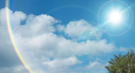 夏の晴天、青空に流れる積乱雲ふわふわの入道雲と輝く太陽のレンズフレア 夏・夏休み・行楽・バカンス・アウトドア・キャンプ・天気・台風一過・紫外線・日焼け 秋・秋晴れ