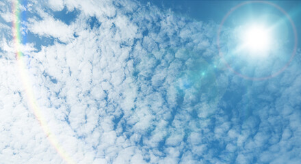 夏の晴天、青空に流れる積乱雲ふわふわの入道雲と輝く太陽のレンズフレア 夏・夏休み・行楽・バカンス・アウトドア・キャンプ・天気・台風一過・紫外線・日焼け 秋・秋晴れ