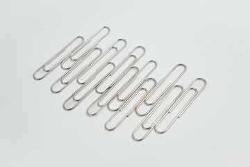 A versatile background element. A heap of metal paper clips provides a subtle texture and metallic sheen, perfect for graphic design related to office, business, or creativity, with ample copy space.