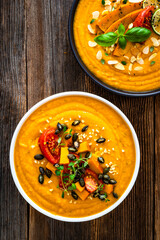 Pumpkin cream soup on wooden table. Top view