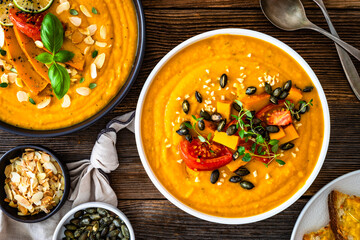 Pumpkin cream soup on wooden table. Top view