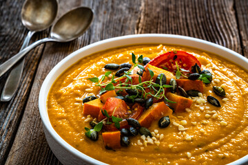 Pumpkin cream soup on wooden table	

