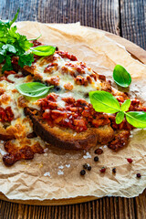 Bolognese sandwich with grilled cheese on wooden table	