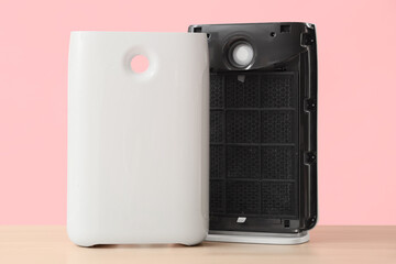 Obraz premium Disassembled air purifier with dirty filter on pink background