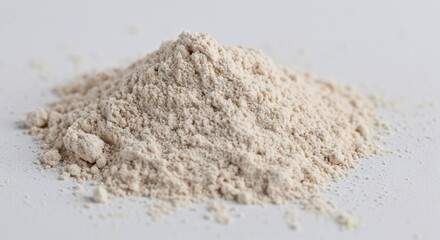 Heap of tan granular powder on a smooth white surface