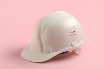 Fototapeta premium White hard hat safety equipment for construction and industrial work, personal protective gear on pink background, the clean design emphasizes workplace safety and occupational health standards