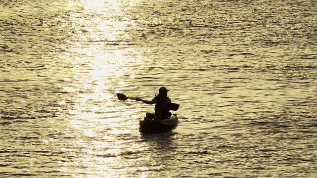 Doha, Qatar - October 04, 2025: silhouette of a girl kayaking at Old Doha Port Mina District early morning
