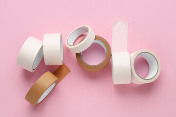 Many rolls of different masking tape on pink background