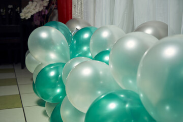 Close-up of inflatable balloons in green tones at a birthday party