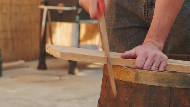 A skilled and dedicated craftsman expertly sawing a wooden plank in his cozy and inviting workshop environment