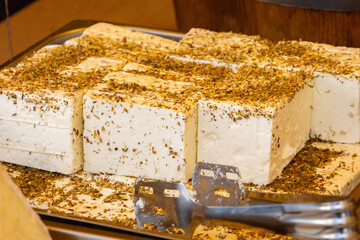 Herb-crusted feta cheese blocks on market display