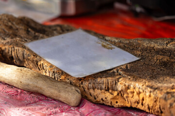 Wooden cutting board with cleaver on red tablecloth in rustic setting