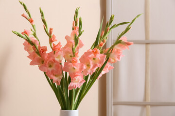 Vase with bouquet of beautiful gladiolus flowers in living room, closeup