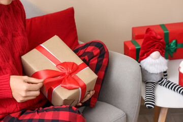 Woman opening beautiful Christmas gift box at home, closeup